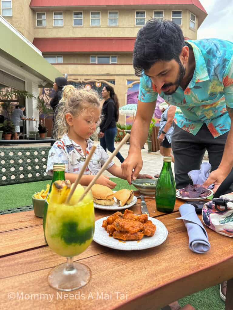 A dad helps a toddler with the food on this plate at The Parlay in Wailuku, Maui, Hawaii. 