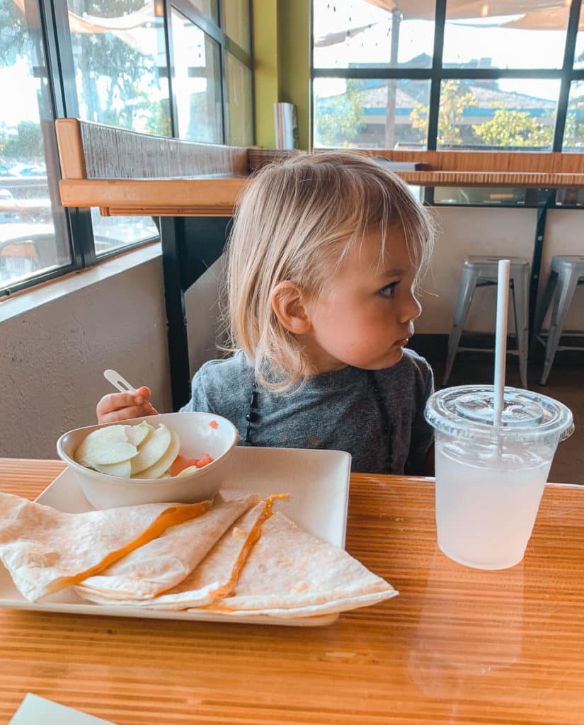 Toddler eating a quesadilla at family-friendly restaurant Fork and Salad restaurant in Maui, Hawaii