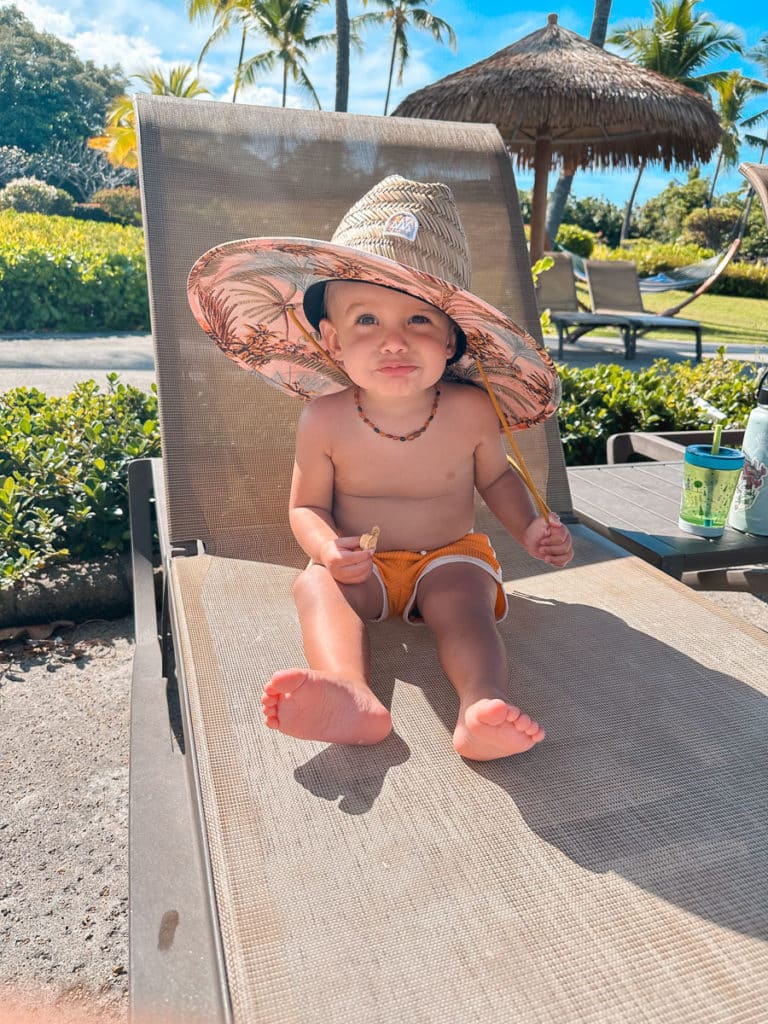 A baby wearing a sun hat at Outrigger Kona Resort and Spa on the Big Island of Hawaii 