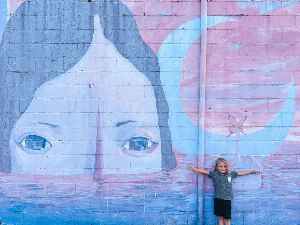 A boy posing in front of a mural in downtown Hilo on the Big Island of Hawaii 