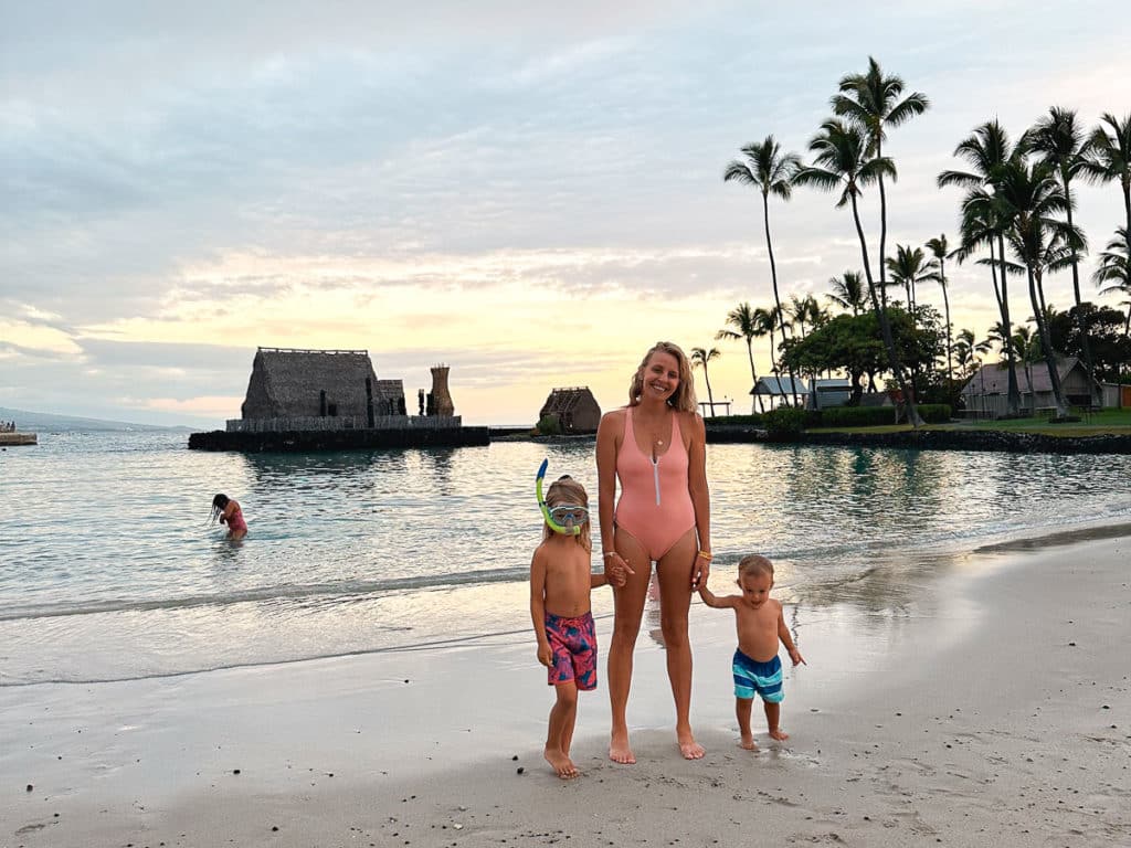 Mom holding hands with two kids at King Kam Beach on the Big Island of Hawaii 