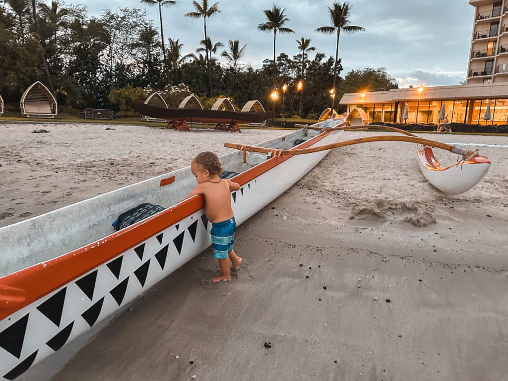 Baby playing in canoe at the Courtyard King Kamehameha's Kona Beach Hotel on the Big Island of Hawaii. 