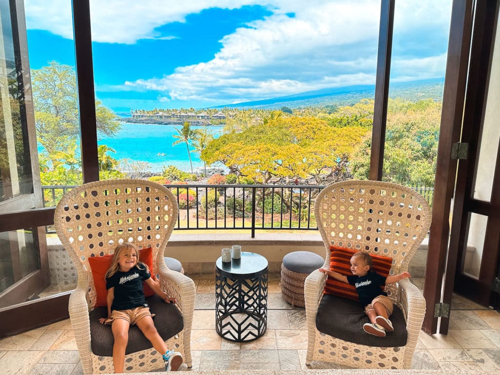 Two kids sitting in chairs at a resort on the Big Island of Hawaii