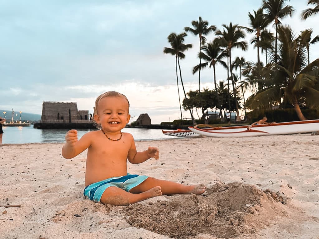 A baby playing in the sand at King Kam Beach on the Big Island in Kona, Hawaii.