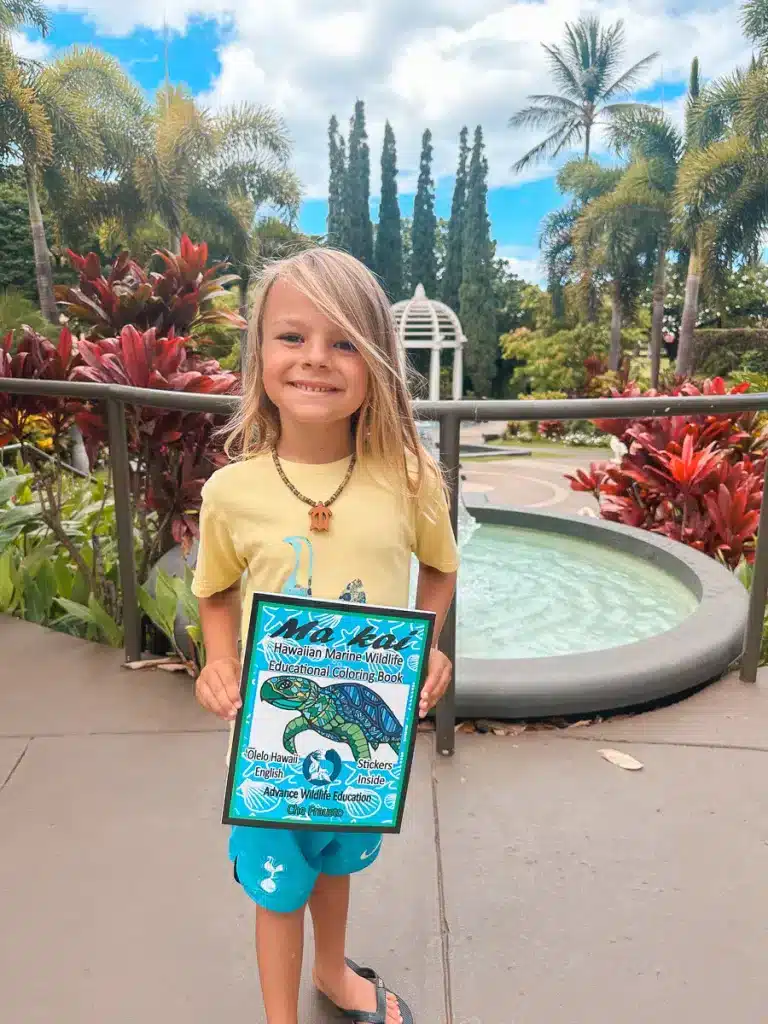 A boy holding a coloring book at the Fairmont Kea Lani in Maui, Hawaii.