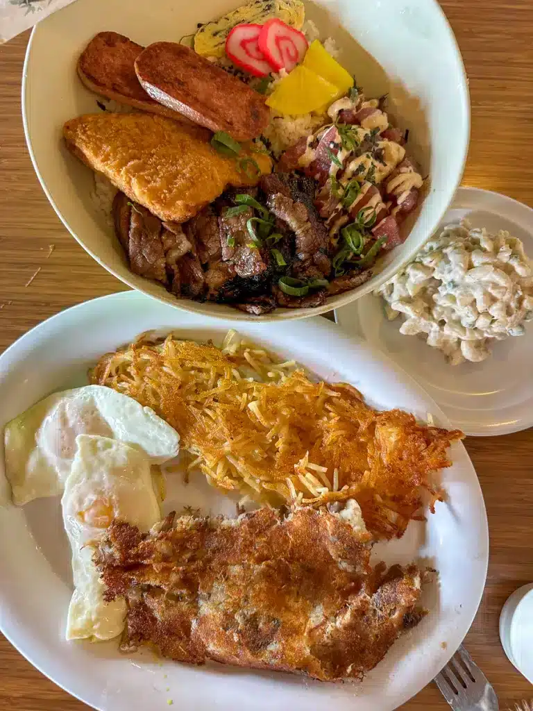 Plates on a table with Mento Bento and Kalua Pork Hash from Hawaiian Style Cafe on the Big Island.