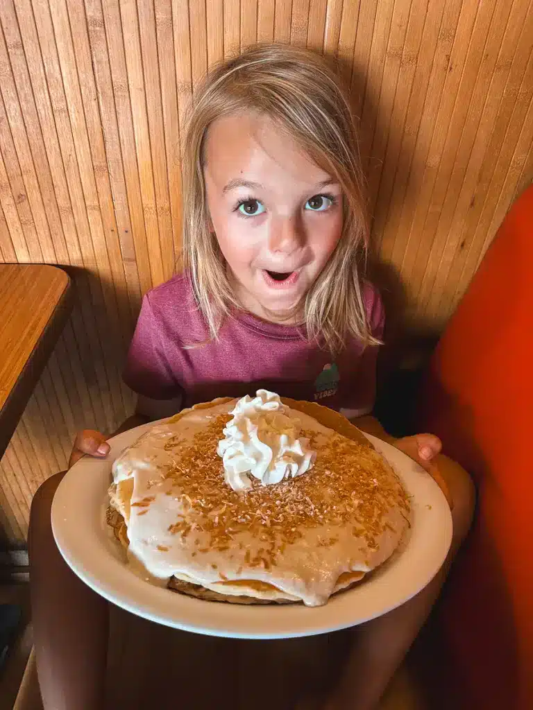 A young boy holding a very large pancake from Hawaiian Style Cafe on the Big Island of Hawaii. 