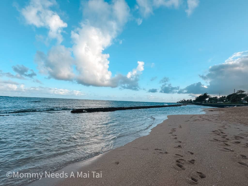 Fuji Beach on Kauai with blue skies a few clouds in the sky. 