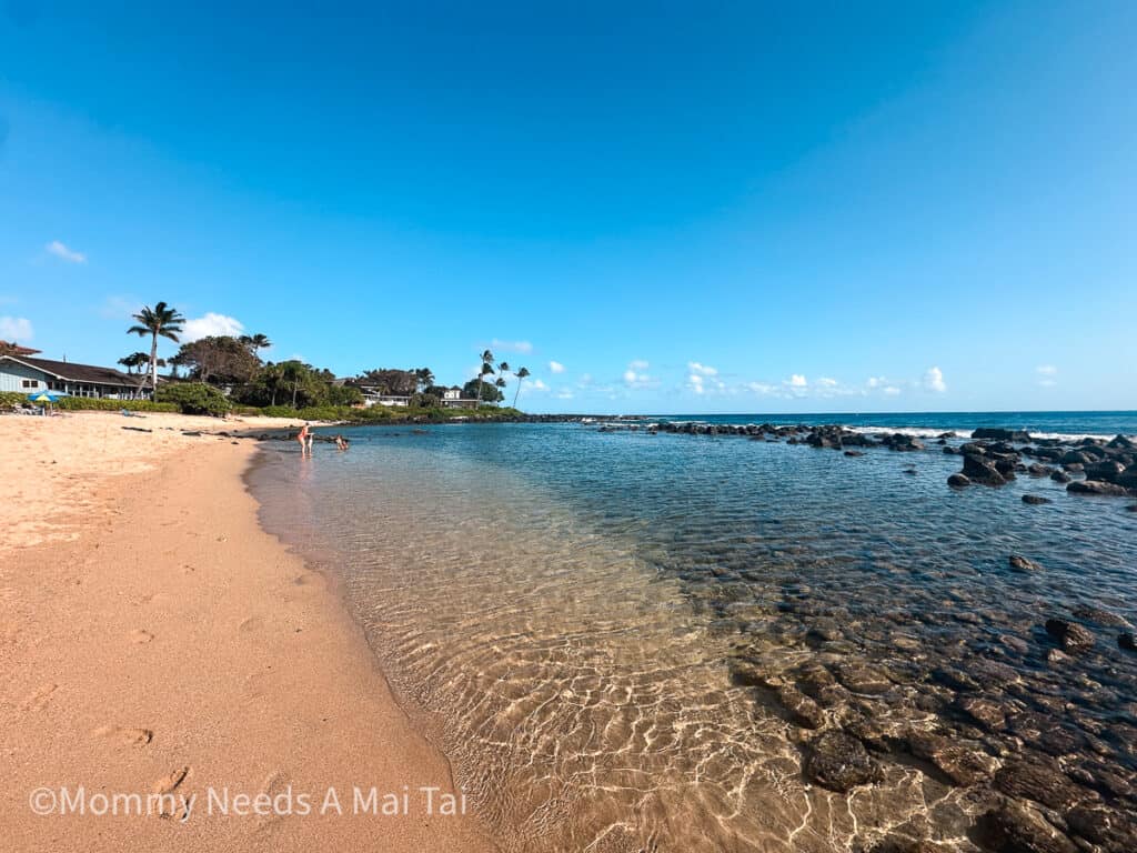 Baby Beach in Poipu, Kauai with kids playing on a sunny day. 