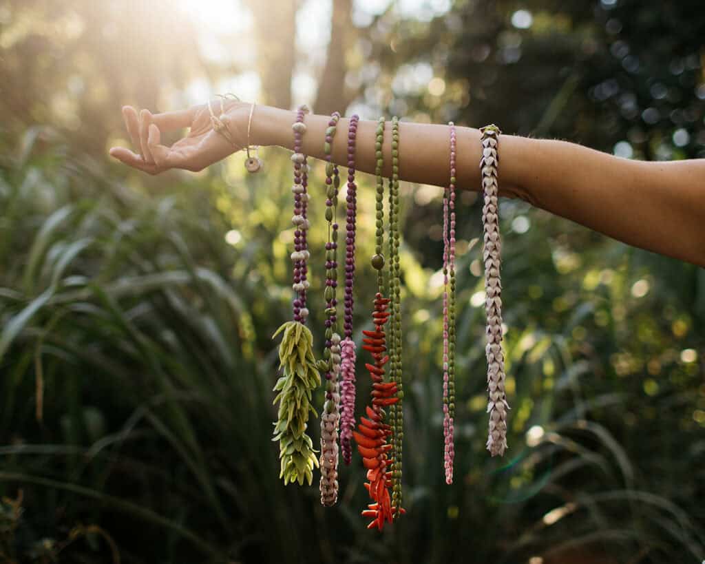 Colorful leis hanging off of a woman's arm in Hawaii.